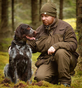 Man med sin hund i skogen