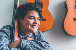 Ensemblemusiker spelar kontrabas och ler