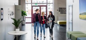 tre deltagare i samtal i skolkorridor