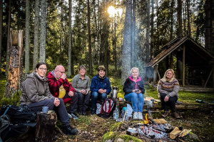 Ett gäng blivande skogsguider sitter runt en brasa i skogen