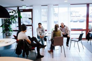 Samtal mellan deltagare och lärare i ring i caféet.