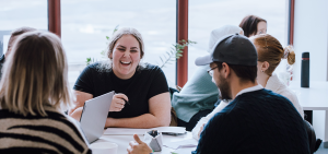 glada deltagare diskuterar runt ett bord i skolans café