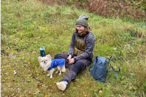 Matte och hund har paus i gröngräset.