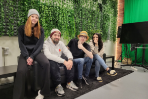4 personer sitter i en soffa framför en greenscreen