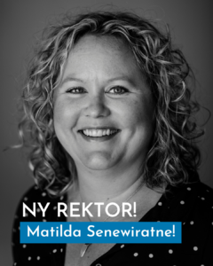 Kvinna med ljus hy och lockar ler mot kameran.