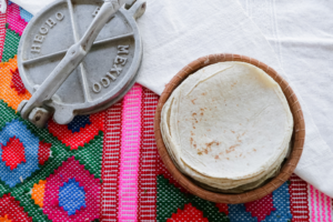Tortillas på en tallrik med en färgglad duk under